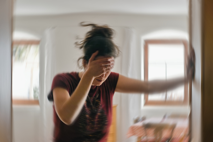 Blurred photo of woman suffering from vertigo or dizziness or other health problem of brain or inner ear.